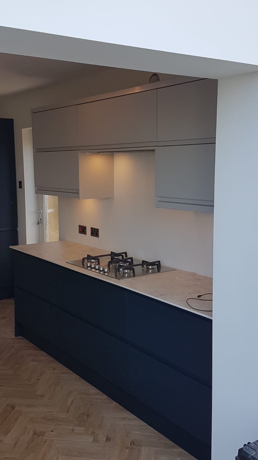 A newly fitted grey and navy kitchen installed as part of a property refurbishment